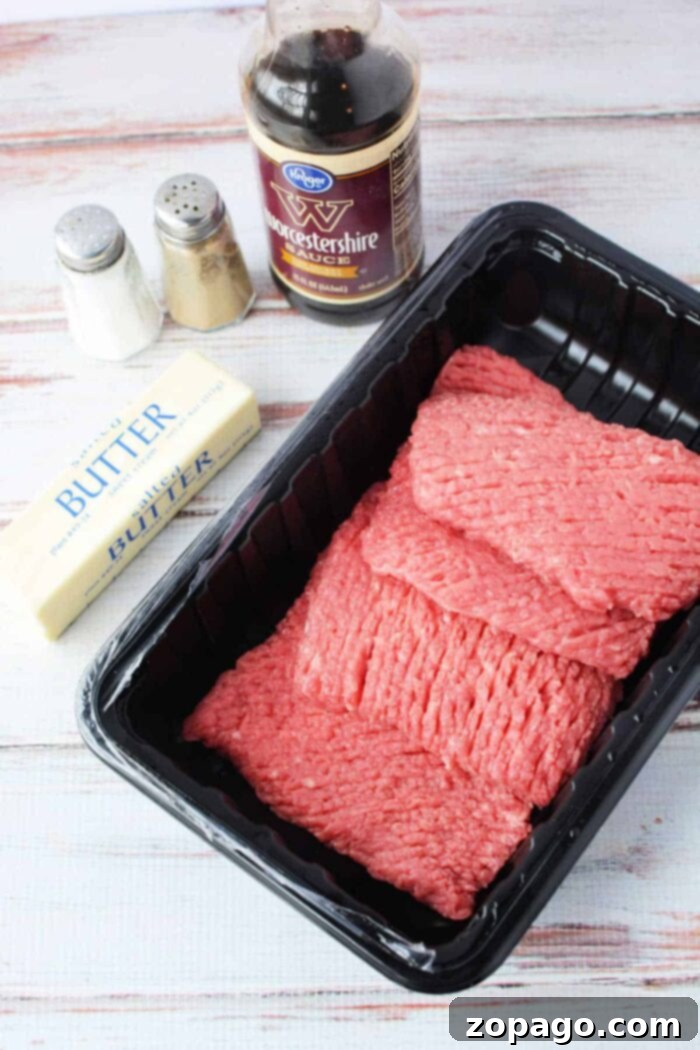 Frying Pan Cube Steak: Master the Cook Time 3 Essential ingredients for pan-fried cube steak: cube steak, Worcestershire sauce, butter, salt, and pepper, arranged on a white wooden surface, ready for a quick and tender meal.