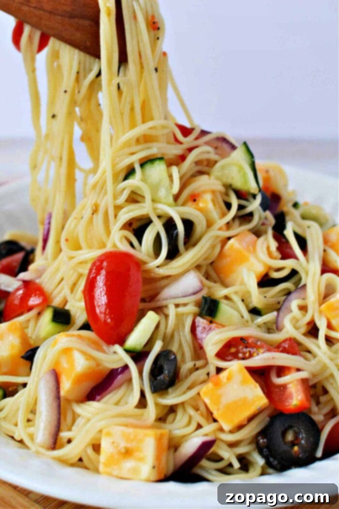 A large serving bowl filled with vibrant Angel Hair Pasta Salad, showcasing the colorful medley of vegetables and pasta.