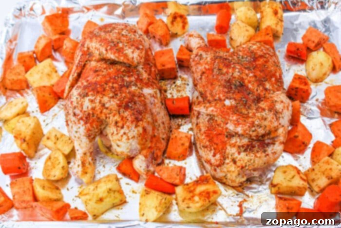 Perfectly Roasted Half Chicken Cooking Time at 400 Degrees 8 A seasoned half chicken resting amid chunks of sweet potatoes and carrots on a foil-lined baking sheet, a complete meal.