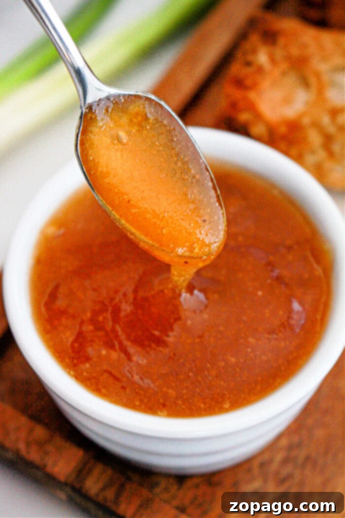Signature Egg Roll Dipping Sauce 5 Crispy egg roll being dipped into a bowl of homemade sauce