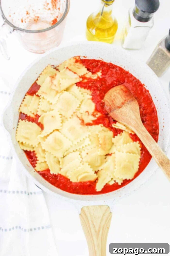 Quick and Tasty Frozen Ravioli 5 Frozen ravioli simmering in a rich sauce on the stove, garnished with fresh herbs