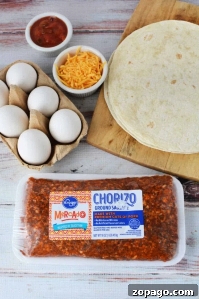 Spicy Chorizo Scramble 3 A rustic wooden surface showcasing the fresh ingredients for a delightful chorizo and eggs dish. Laid out are soft flour tortillas on a cutting board, a carton of farm-fresh eggs, a bowl overflowing with grated cheddar cheese, a small bowl of vibrant salsa, and a package of Kroger Mercado ground Mexican chorizo sausage. These components are perfectly arranged for anyone eager to learn how to cook chorizo and eggs for an authentic breakfast.