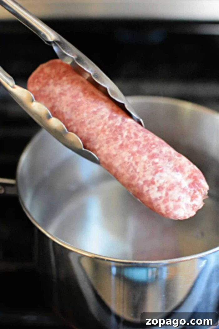 The Perfect Boil Time for Brats 4 Chef's tongs holding raw bratwurst over a steaming pot of boiling water, illustrating preparation.