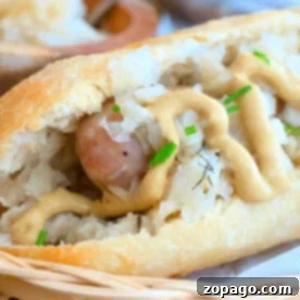 Boil Brats Perfectly Every Time 7 Close-up of a bratwurst in a bun topped with sauerkraut, mustard, and chives on a woven basket. As you savor this delight, ponder how long to boil brats for that perfect juiciness before grilling.