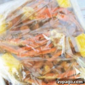 Learn how to cook seafood in a bag with our easy guide. This seafood boil, presented on a tray, features succulent shellfish elegantly combined with corn and spices—all sealed within a plastic bag to enhance flavor.