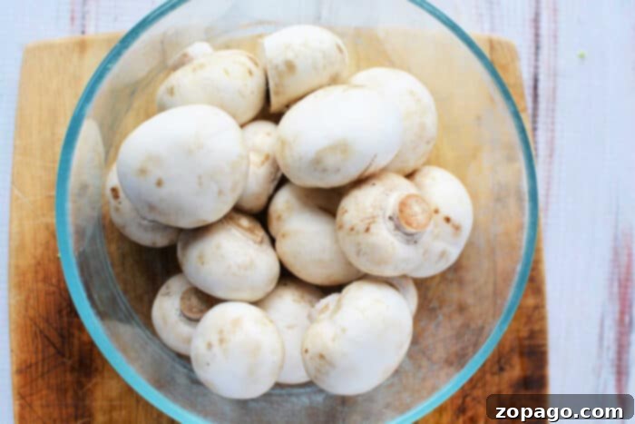 Simmered Mushrooms 3 Boiling white button mushrooms in a pot on the stove.