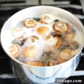 Boiled mushrooms bubble gently in a pot on the stovetop, releasing a savory aroma into the kitchen air.