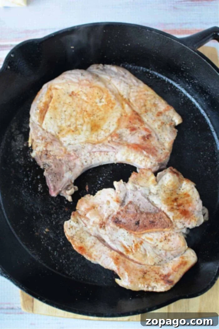 Tender Pork Chops Smothered in Rich Mushroom Gravy 6 Succulent mushroom pork chops, ready to be served, glistening with rich gravy.