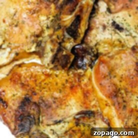 Juicy Broiled Pork Chops 6 Broiled pork chops seasoned with herbs and spices rest elegantly on a pristine white plate.