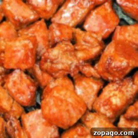 A close-up of seasoned and cooked meat pieces, their glossy reddish-brown coating revealing the secrets of how to cook steak tips in the oven to perfection.