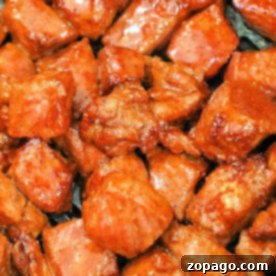 A close-up of seasoned and cooked meat pieces, their glossy reddish-brown coating revealing the secrets of how to cook steak tips in the oven to perfection.