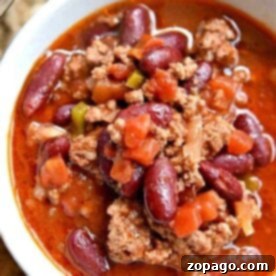A hearty bowl of chili with dried beans, featuring ground meat, kidney beans, tomatoes, and peppers in a savory sauce.