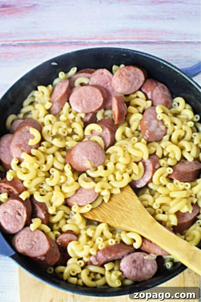 Hearty Kielbasa Pasta Skillet 7 Sausage macaroni and cheese in a skillet, garnished with fresh herbs
