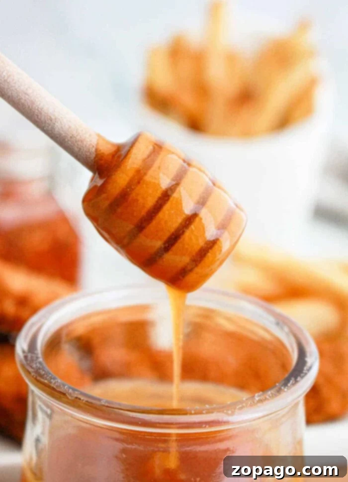 Homemade Hot Honey: Sweet Heat Perfection 2 Homemade Hot Honey Sauce drizzled over chicken wings, capturing the perfect sweet and spicy glaze
