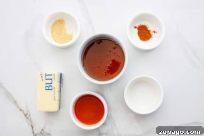Whip Up Your Own Hot Honey 3 Essential ingredients laid out for making hot honey sauce: honey, butter, hot sauce, and spices.