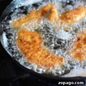 Golden chicken strips sizzle in the hot oil, surrounded by a flurry of bubbles as they transform into crispy perfection. Discover how to fry chicken tenders just right for that irresistible crunch with each bite.