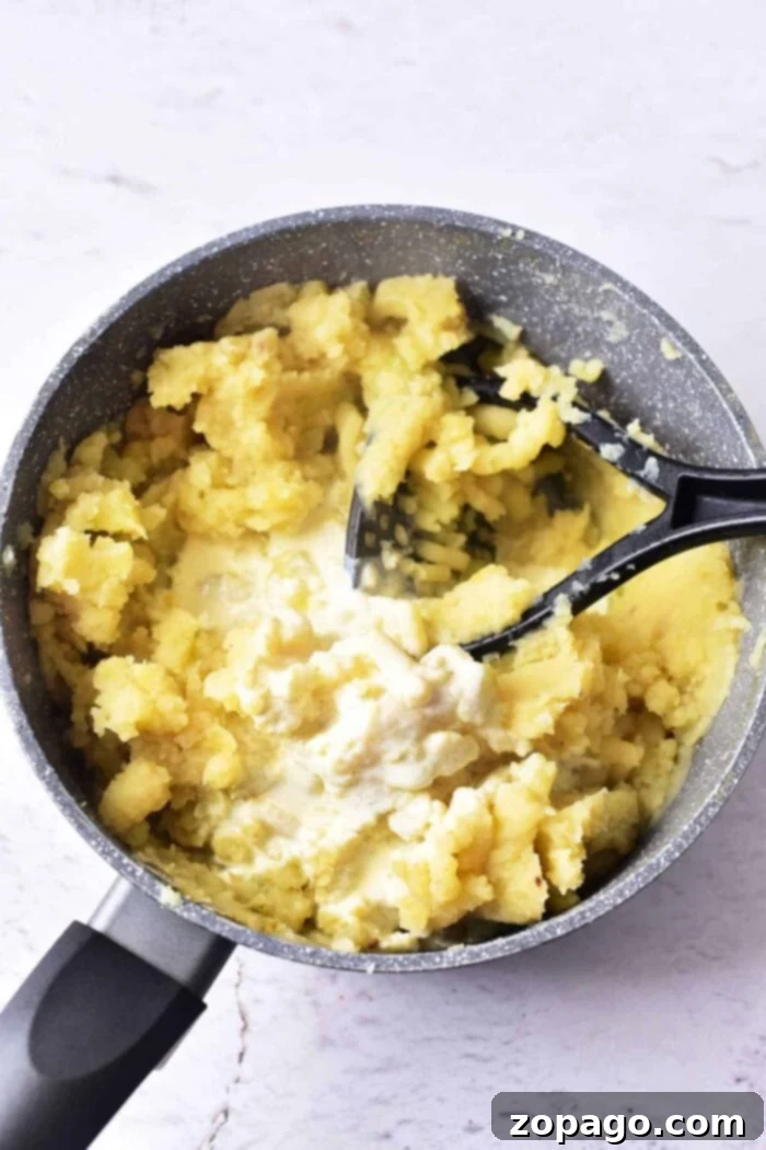 Velvety Garlic Confit Mashed Potatoes 4 A serving of luxurious duck confit mashed potatoes, garnished with fresh herbs, ready to be enjoyed.