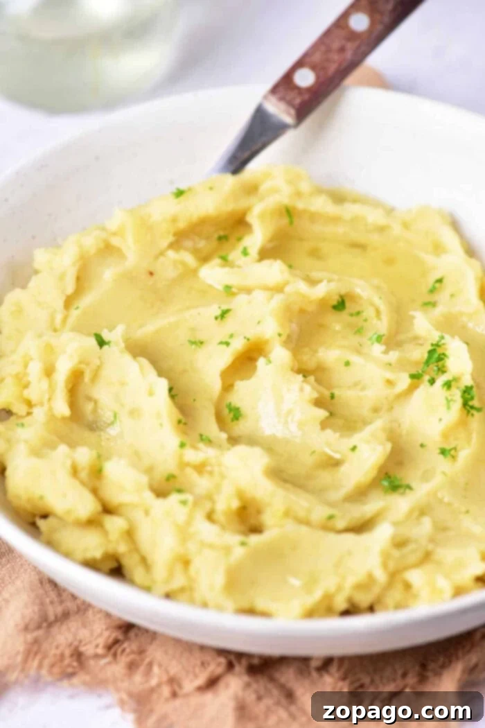 Velvety Garlic Confit Mashed Potatoes 5 Golden brown potato confit, cooked in duck fat, highlighting the rich texture before mashing.