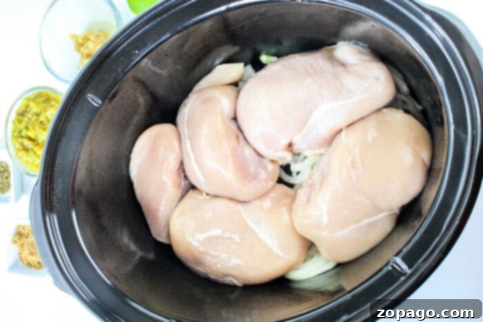Melt-in-Your-Mouth Green Chili Chicken 4 Diced green chiles mingling with chicken in a slow cooker, absorbing flavors.