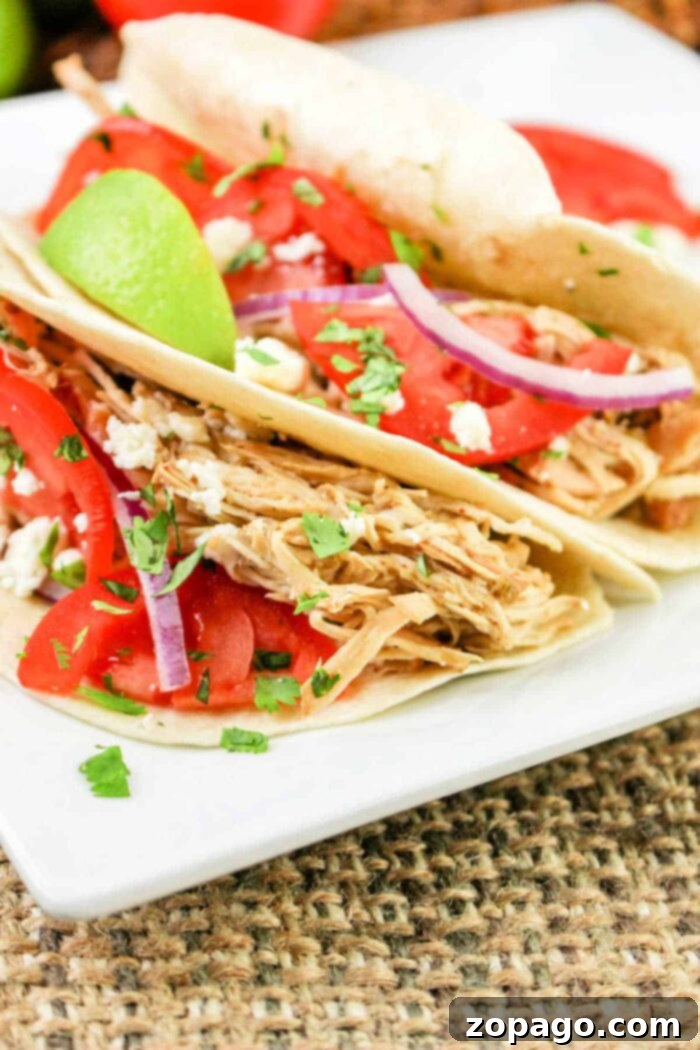 Zesty Slow Cooker Green Chili Chicken 8 Green chile chicken tacos on a plate, garnished with fresh cilantro.