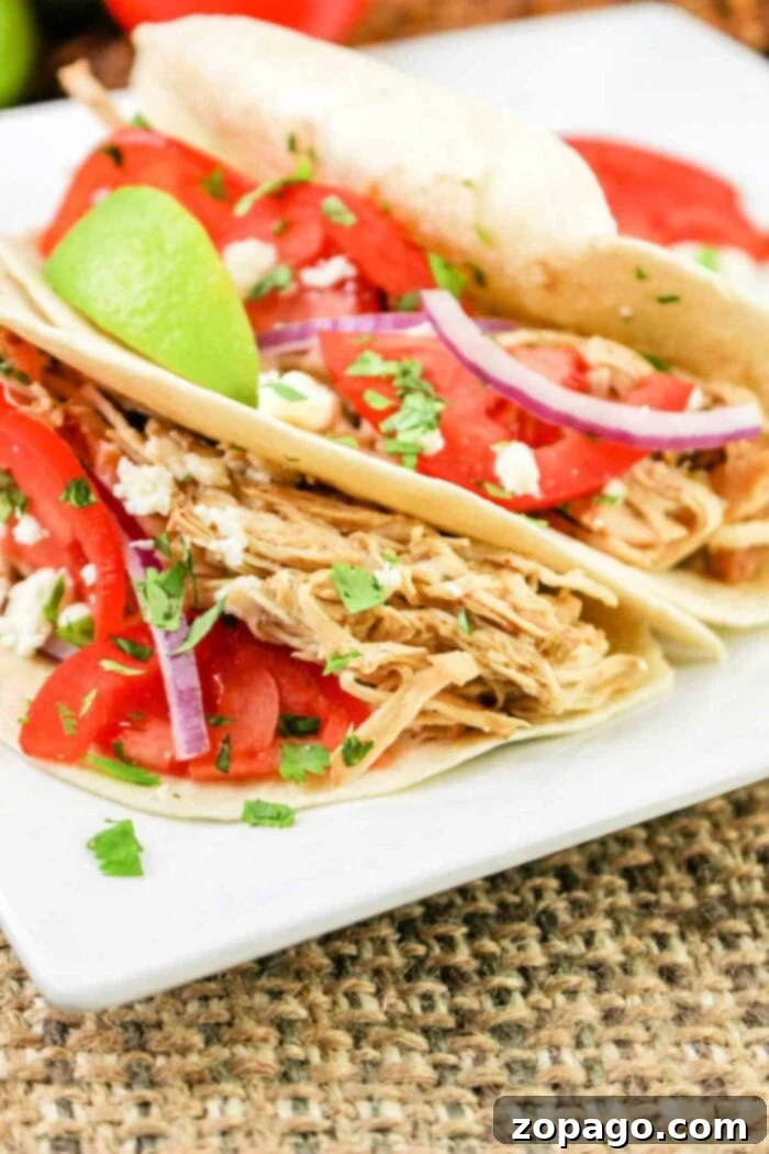 Melt-in-Your-Mouth Green Chili Chicken 7 Delicious green chile chicken tacos, garnished with fresh cilantro and lime.