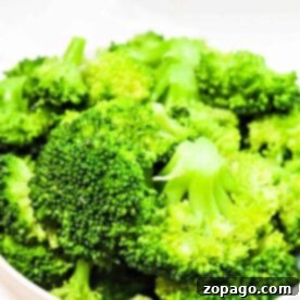 Close-up of fresh broccoli florets in a white bowl, showcasing vibrant green colors and detailed textures, perfect for the Ninja Foodis versatile cooking capabilities.