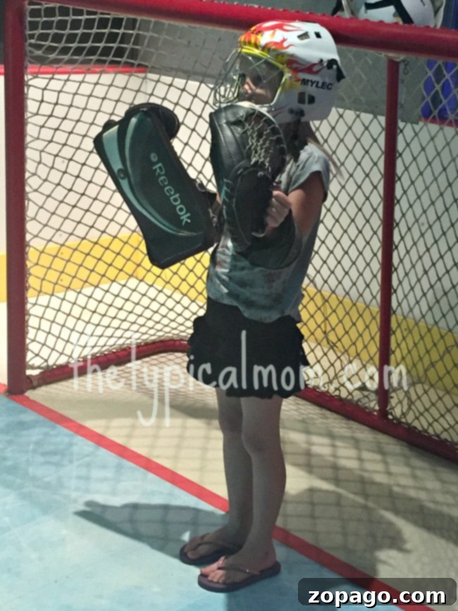 Santa Ana Science Discovery Center 3 A child in hockey gear, including a helmet, glove, and blocker, stands ready at a goal net, embodying the spirit of active learning at Discovery Cube OC Santa Ana.