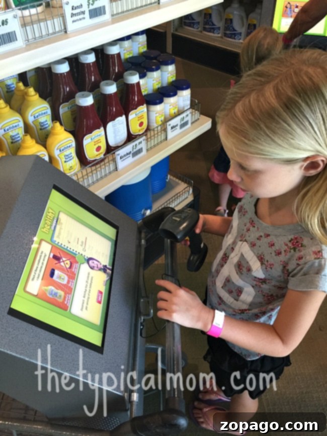 Santa Ana Science Discovery Center 4 A young girl expertly uses a touchscreen kiosk in a vibrant grocery aisle exhibit, mirroring the interactive learning environment found at Discovery Cube OC Santa Ana.