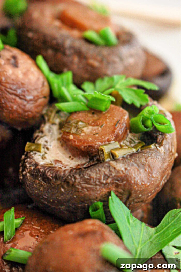 Simple Savory Crockpot Mushrooms 5 Hearty crockpot mushrooms, generously topped with fresh herbs and a slice of savory sausage, promising a truly delightful culinary experience.