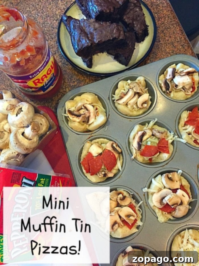 Easy Muffin Tin Pizzas: Quick & Kid-Friendly Dinner A tray of uncooked mini muffin tin pizzas awaits, topped with mushrooms and pepperoni, showcasing a delightful muffin tin dinner idea. A jar of pasta sauce and a box of pepperoni sit nearby. In the background, dark-colored baked items rest on a plate.
