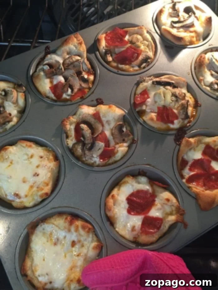 Delicious Baked Muffin Tin Pizzas A close-up of baked mini muffin tin pizzas, golden brown and topped with melted cheese and pepperoni, ready to be served.