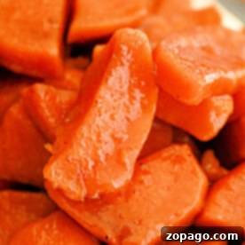 Close-up of slow cooker candied sweet potato slices with a glossy, caramelized finish.