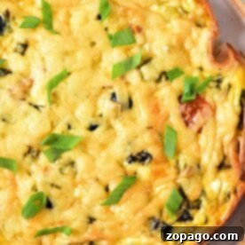 A close-up of a Cottage Cheese Quiche on a white plate with a golden-brown crust, melted cheese, and chopped green onions.