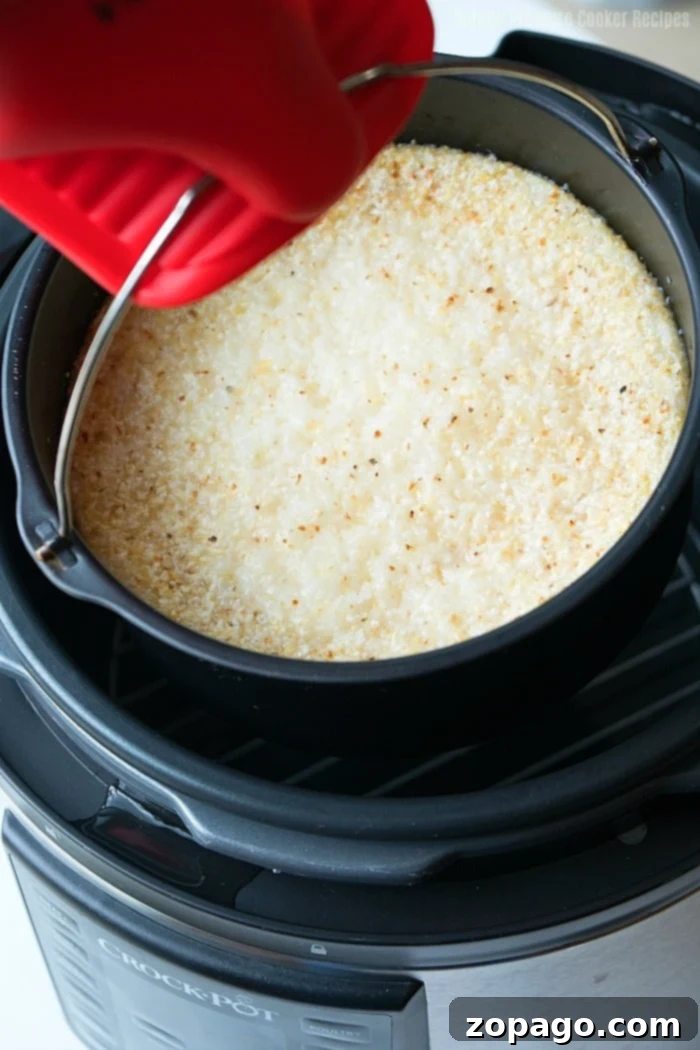 Speedy Crock Pot Express Grits 5 Close-up of creamy, cheesy grits with a spoon, ready to be enjoyed