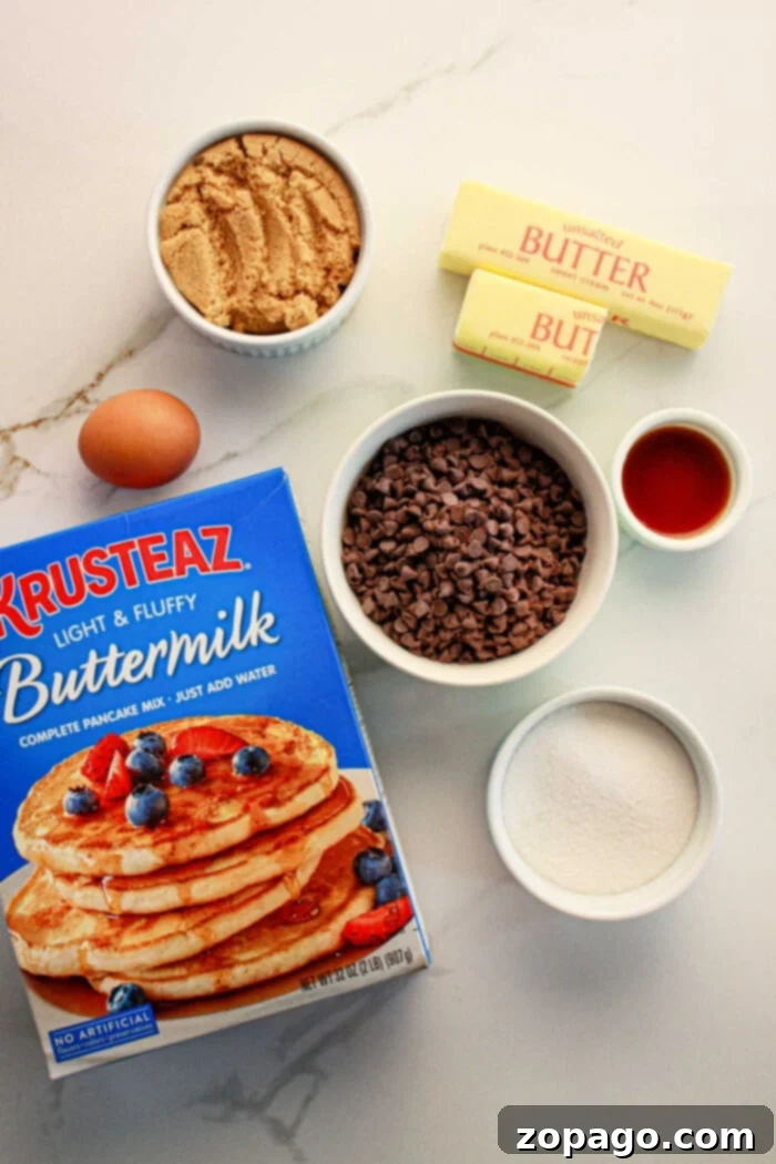 Pancake Mix Cookie Hack 3 Essential ingredients for baking pancake mix cookies arranged neatly on a countertop: a box of premium pancake mix, a bowl of rich brown sugar, a handful of chocolate chips, two sticks of softened butter, a small dish of vanilla extract, white granulated sugar, and a fresh egg.