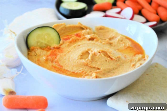 Effortless Hummus: Canned Chickpea Edition 5 A bowl of freshly made hummus with pita bread and vegetables, ready to serve.