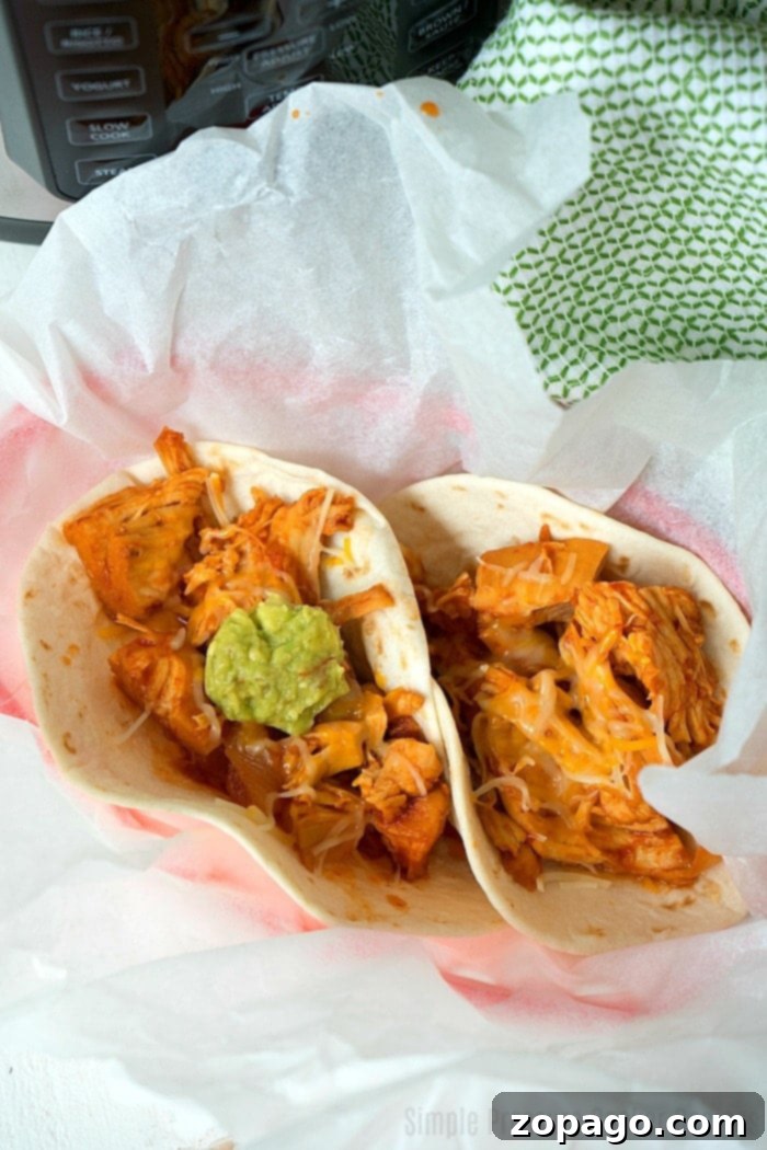 Shredded BBQ chicken in a Crock Pot Express, ready to be served.