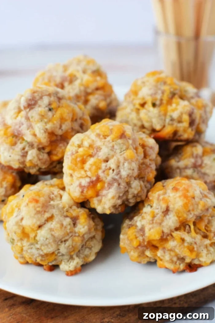 Red Lobster Biscuit Sausage Poppers 2 A plate of golden-brown, baked sausage balls with visible cheese, made using Red Lobster biscuit mix, piled together on a clean white serving dish, ready to be enjoyed as a delicious party appetizer.