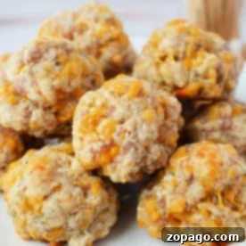 A plate of baked sausage balls with cheese, crafted from biscuit mix, piled together on a white dish.