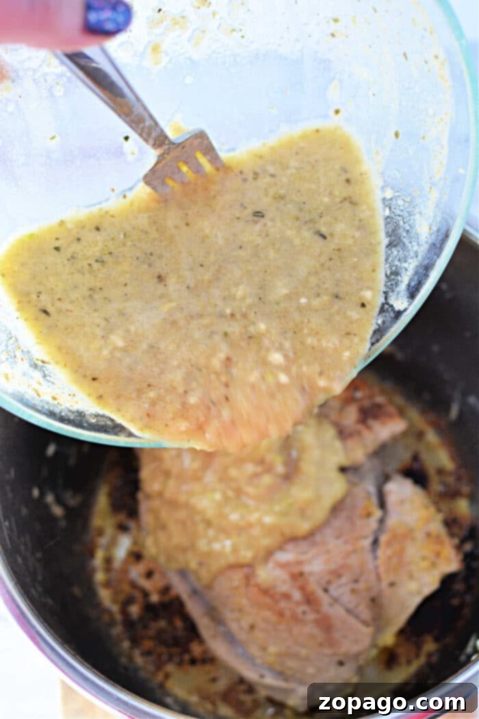 Perfectly Roasted Pork Sirloin 5 Pouring yellow marinade over pork in a pot, using a fork to scrape from a glass bowl.