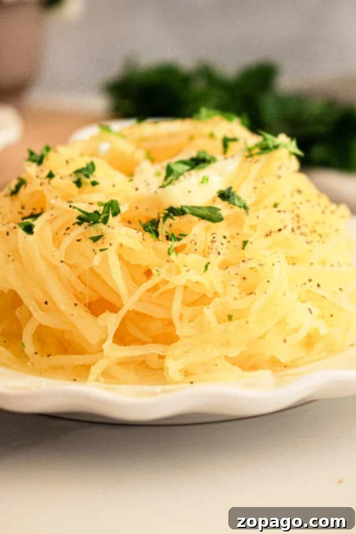 Effortless Slow Cooker Spaghetti Squash 8 A slow cooker spaghetti squash sits on the plate, enhanced by a parsley garnish and a sprinkle of black pepper.
