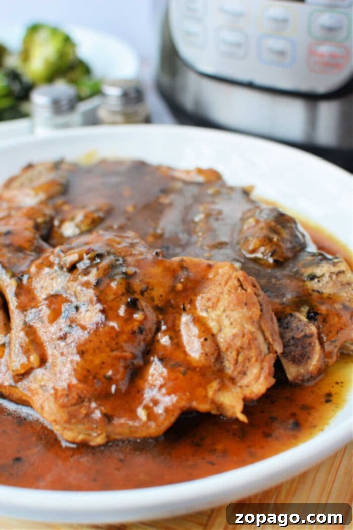 Perfect Pork Steaks 7 A plate of tender pork steaks generously covered in a rich brown gravy, accompanied by an Instant Pot and fresh broccoli in the background, signaling a wholesome homemade meal.