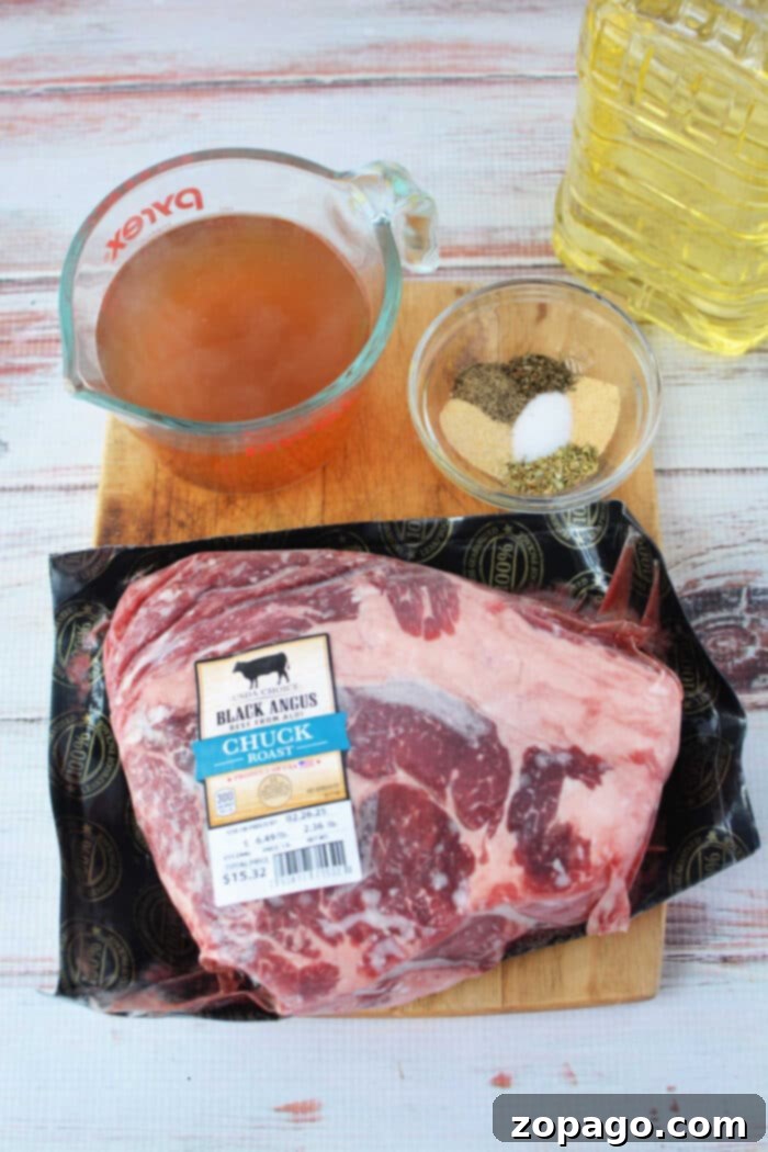 Easy Stovetop Pot Roast 3 Stove Top Pot Roast ingredients: raw chuck roast, spices in a bowl, vegetable oil, and beef broth in a measuring cup all rest invitingly on the wooden surface.