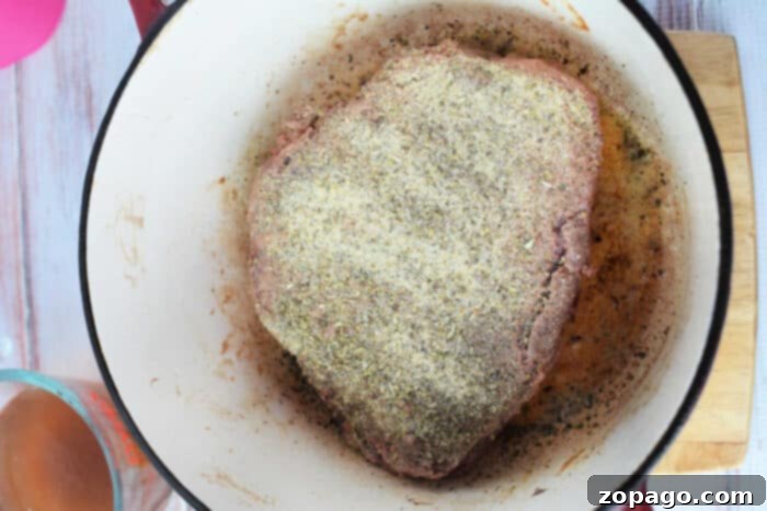 Easy Stovetop Pot Roast 4 A seasoned raw meat roast sits in a pot, poised for cooking into a delicious stove top pot roast.