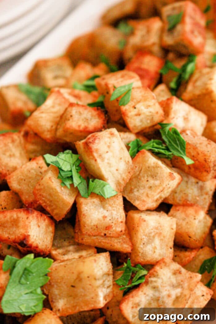 Creamy White Sweet Potato Delight 2 A pile of crispy roasted white sweet potato cubes garnished with fresh parsley.