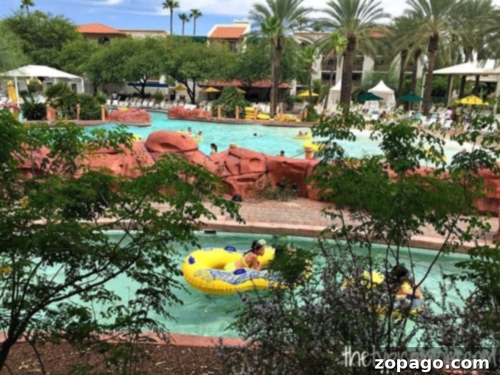 Arizona Grand Resort A Comprehensive Review 3 At the Arizona Grand Resort, the outdoor pool area features a lively lazy river where guests relax on inflatable tubes, surrounded by tropical plants and palm trees. Lounge chairs invite visitors to unwind in this sun-soaked paradise.