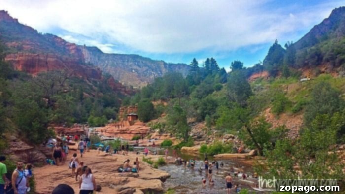 Families enjoying the natural slides at Slide Rock State Park, Sedona. Children playing and sliding down the natural rock slides at Slide Rock State Park in Sedona, Arizona, surrounded by scenic red rock cliffs.