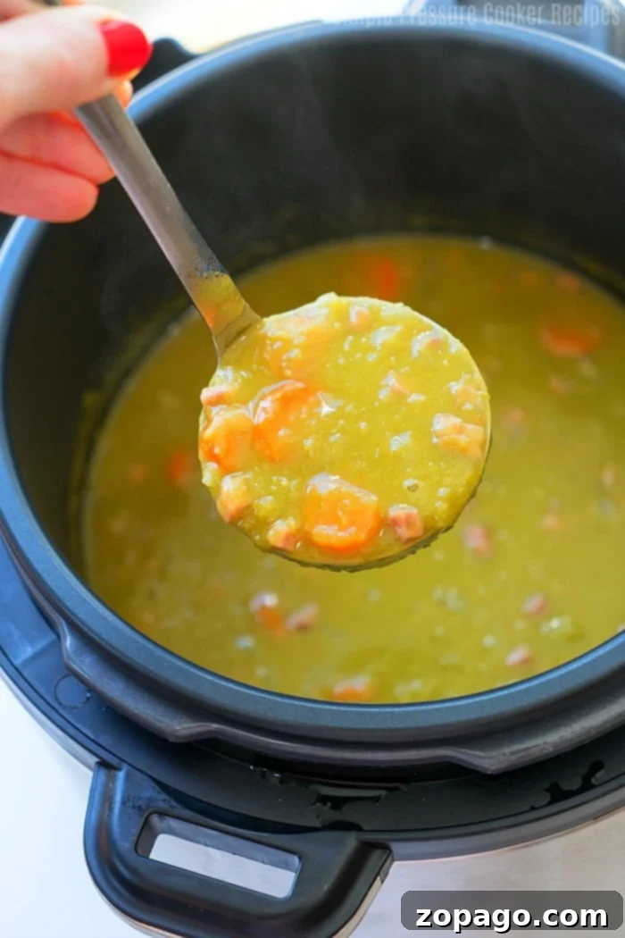 Comforting Crock Pot Express split pea soup, an easy and healthy pressure cooker recipe with dry peas, ready in under 20 minutes. A serving of Crock Pot Express Split Pea Soup in a white bowl, with a spoon and fresh bread on the side.