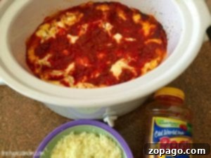 Easy crockpot lasagna recipe featuring a rich tomato sauce and gooey cheese. A jar of Ragu sauce and a bowl of shredded cheese rest beside the slow cooker, ready to create this deliciously simple dish.