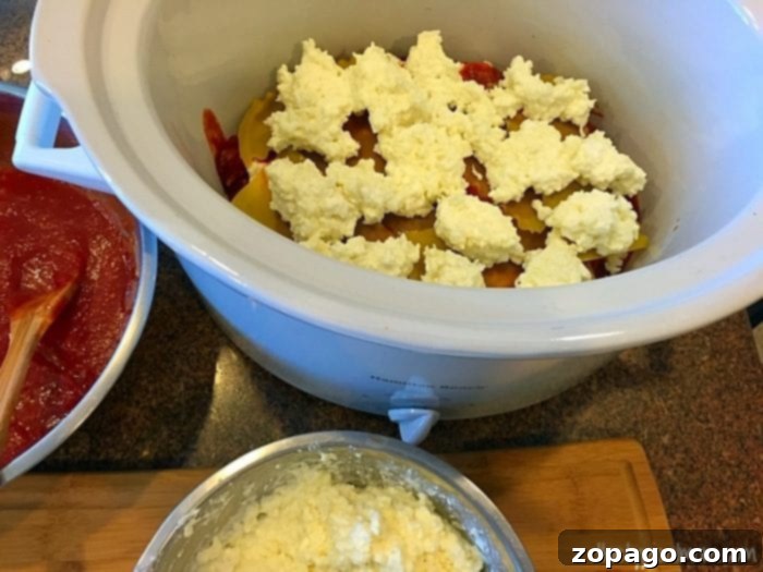 Assembled crockpot lasagna layers before slow cooking. Crockpot lasagna layers ready for cooking.
